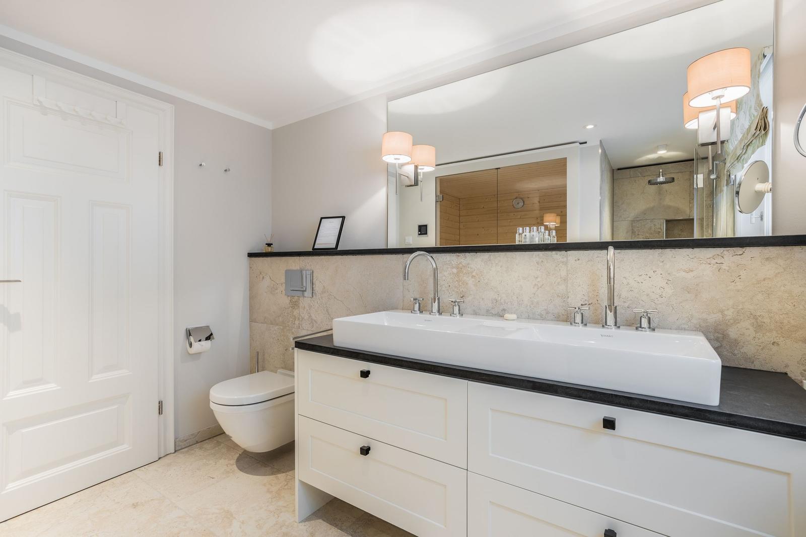 Badezimmer mit Waschtisch, Spiegel und Dusche