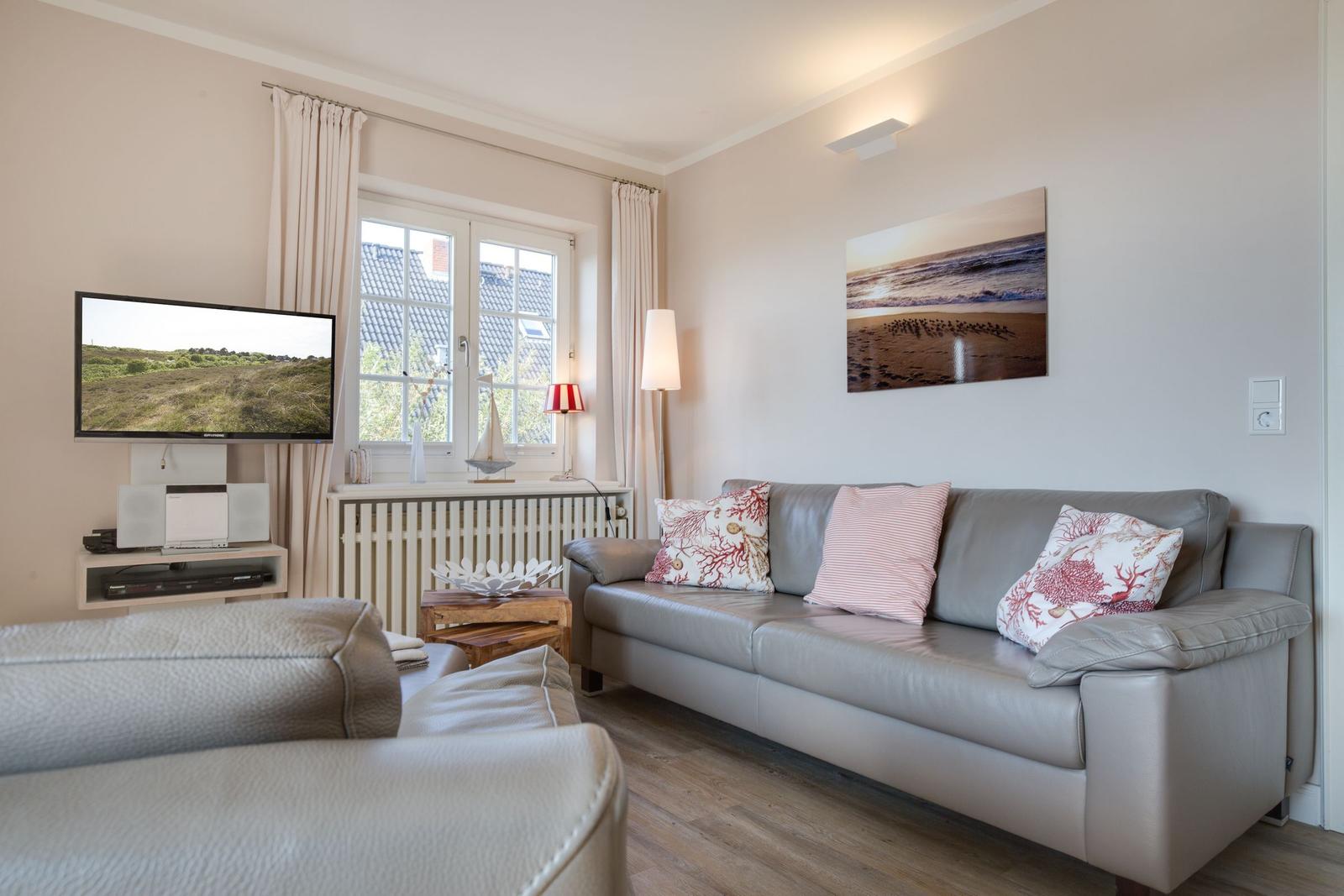 Wohnzimmer mit Sofa, Fernseher und Fenster mit Blick.