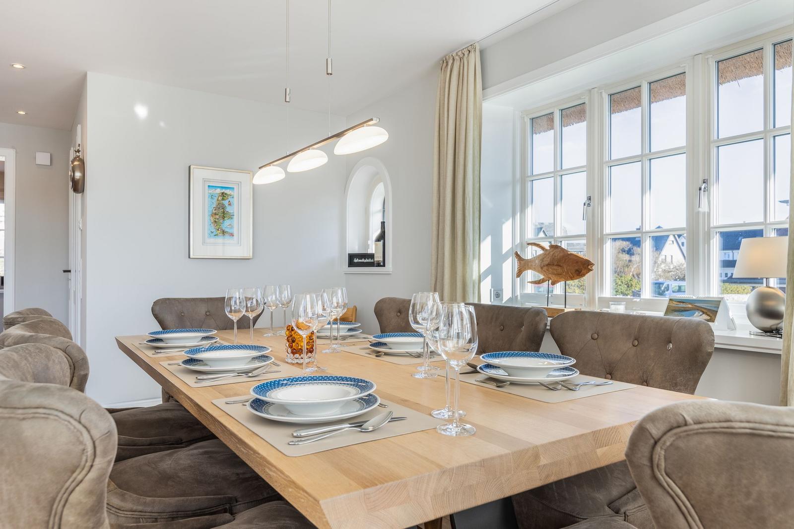 Dining room with wooden table, chairs, and window view.