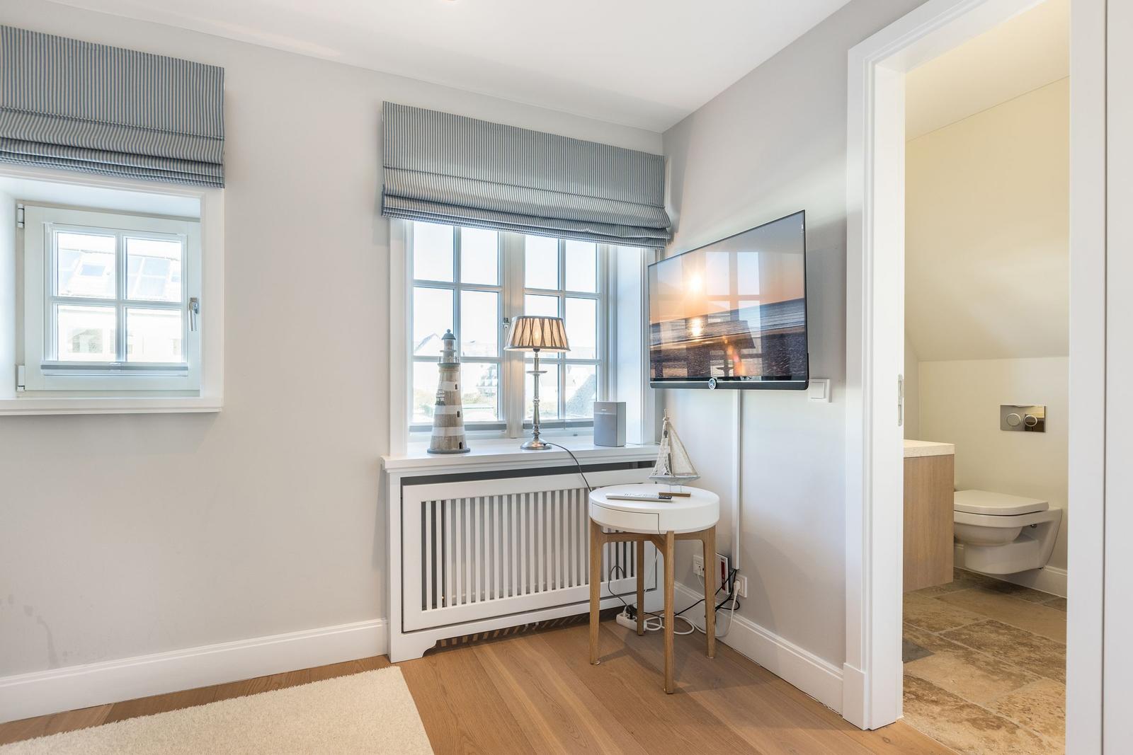 Room with window, TV, and view into the toilet