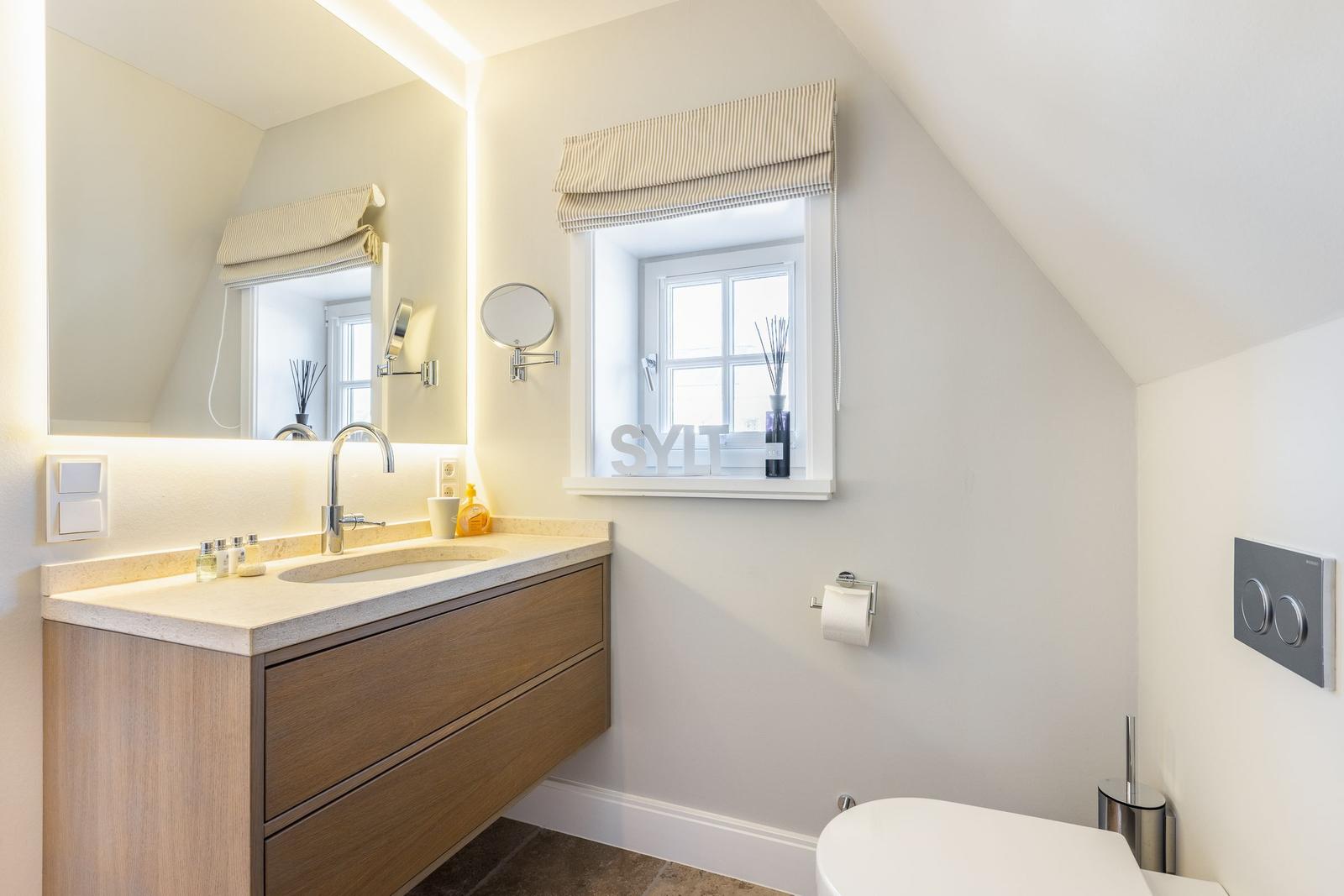 Bathroom with sink, mirror, and window.