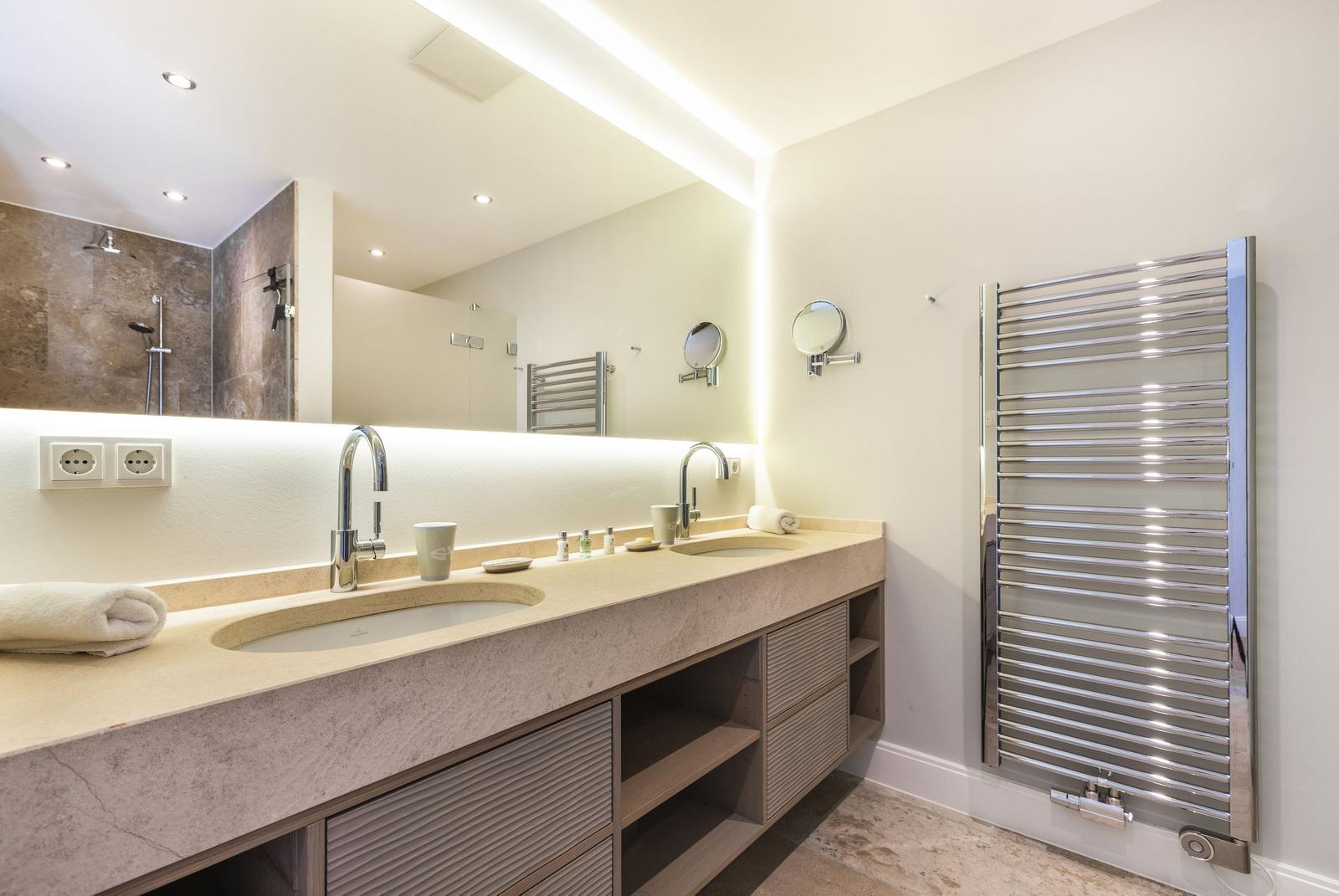 Bathroom with double sink, mirror cabinet, and heated towel rail.