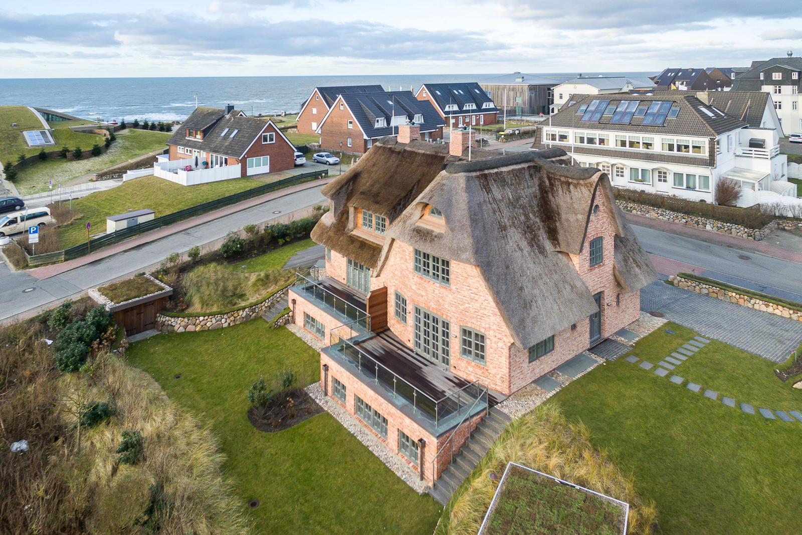 House with thatched roof and terrace by the coast