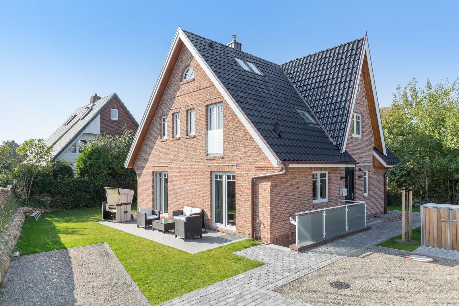 Modernes Backsteinhaus mit Terrasse und Garten.