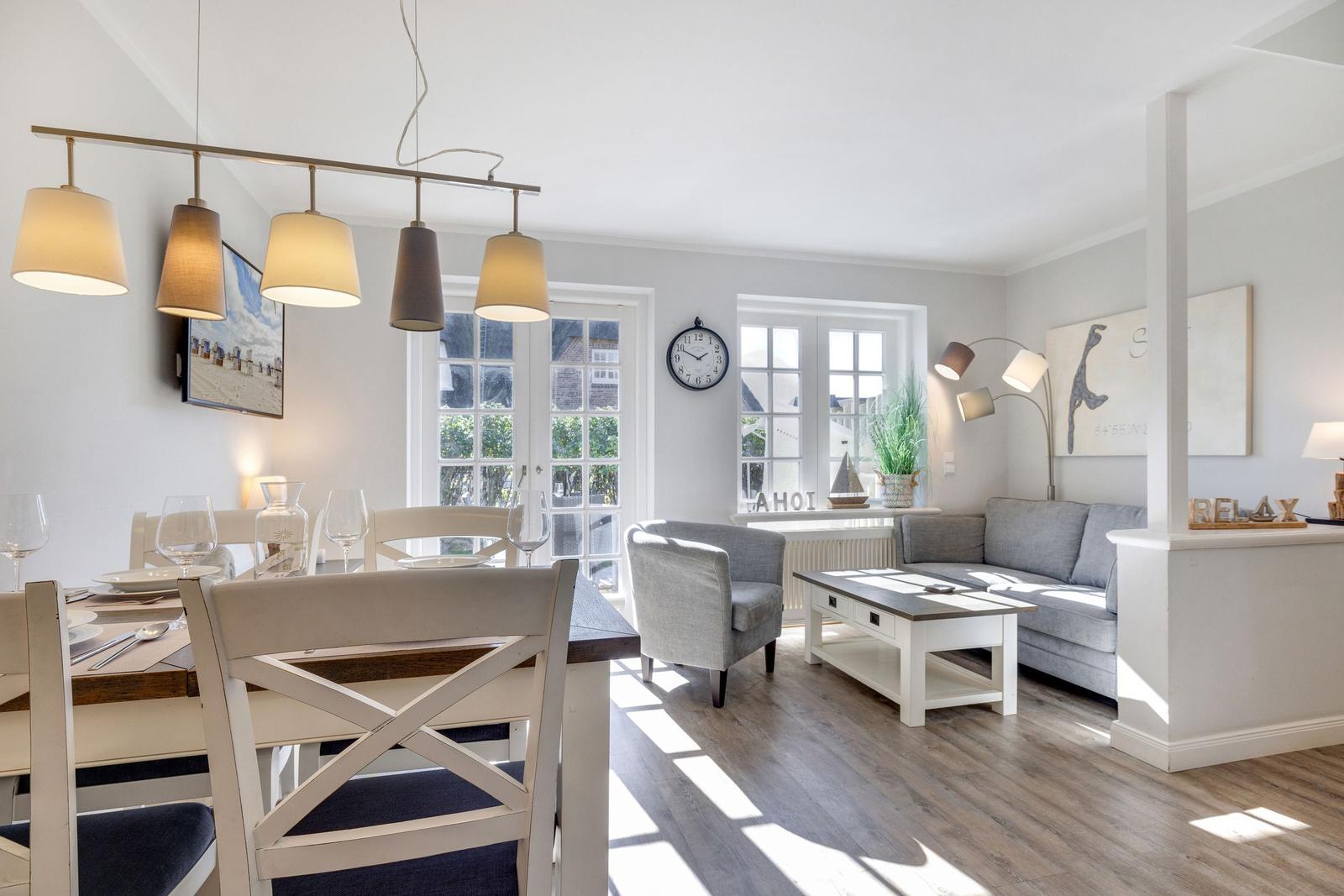 Essbereich mit Tisch und Stühlen, Wohnzimmer mit Sofa und Couchtisch.