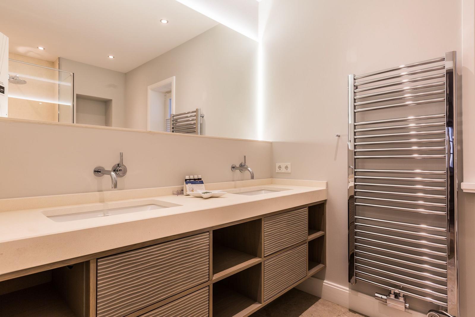 Badezimmer mit Doppelwaschbecken, Spiegel und Heizkörper