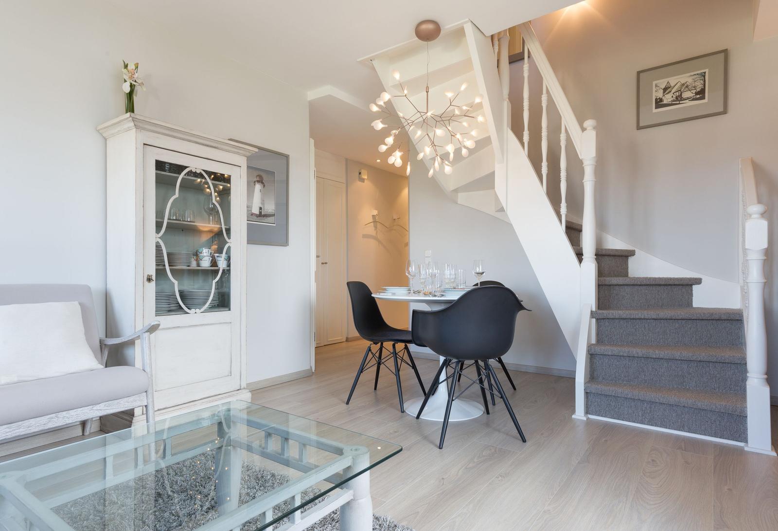 Living and dining area with staircase and glass table