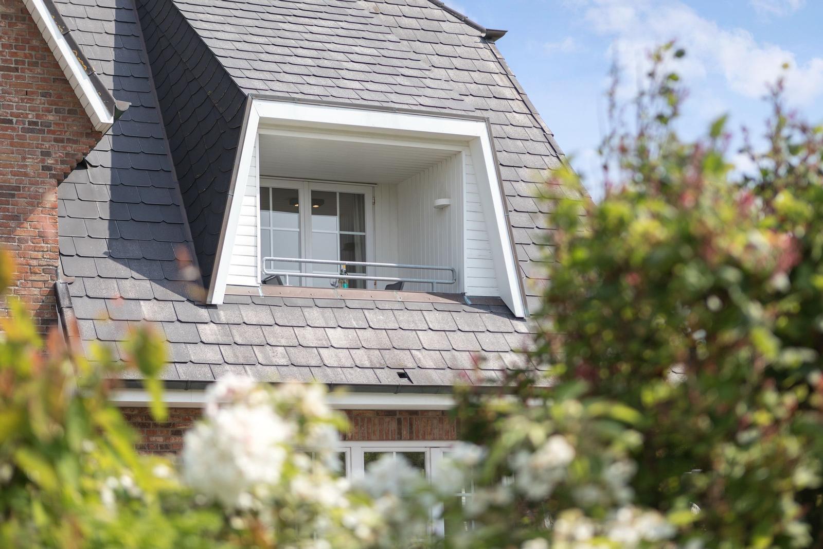 Attic apartment with balcony and gray slate roof