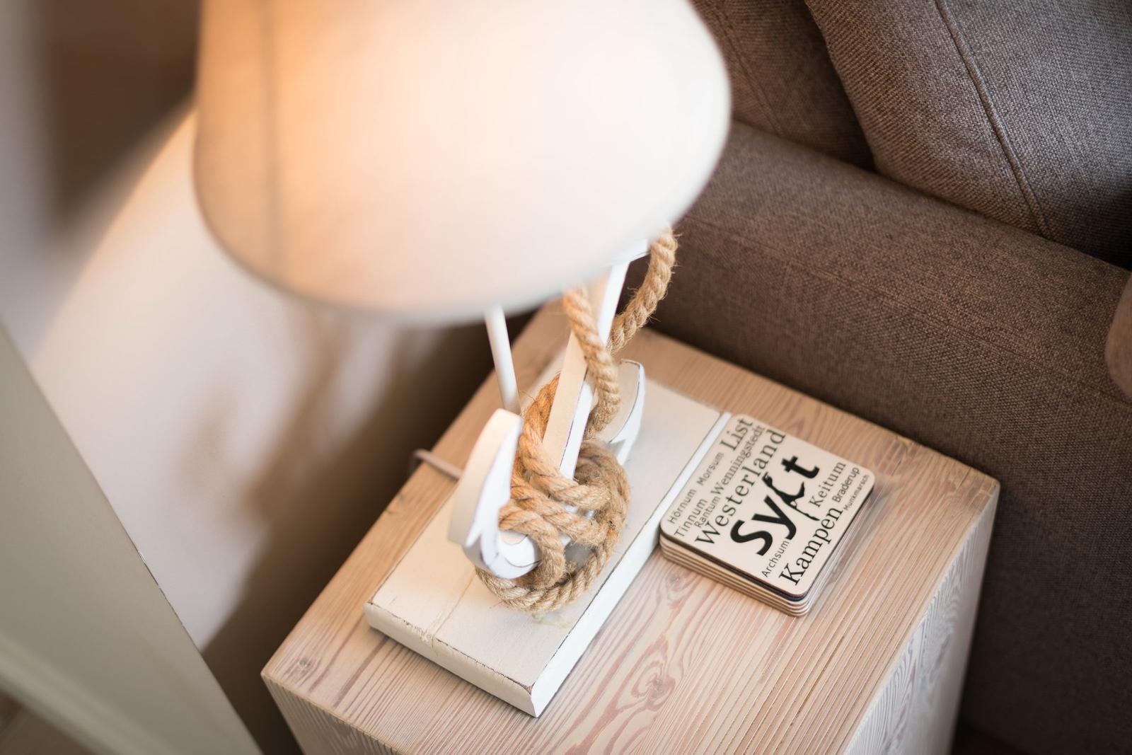 Lamp with rope on wooden table next to sofa