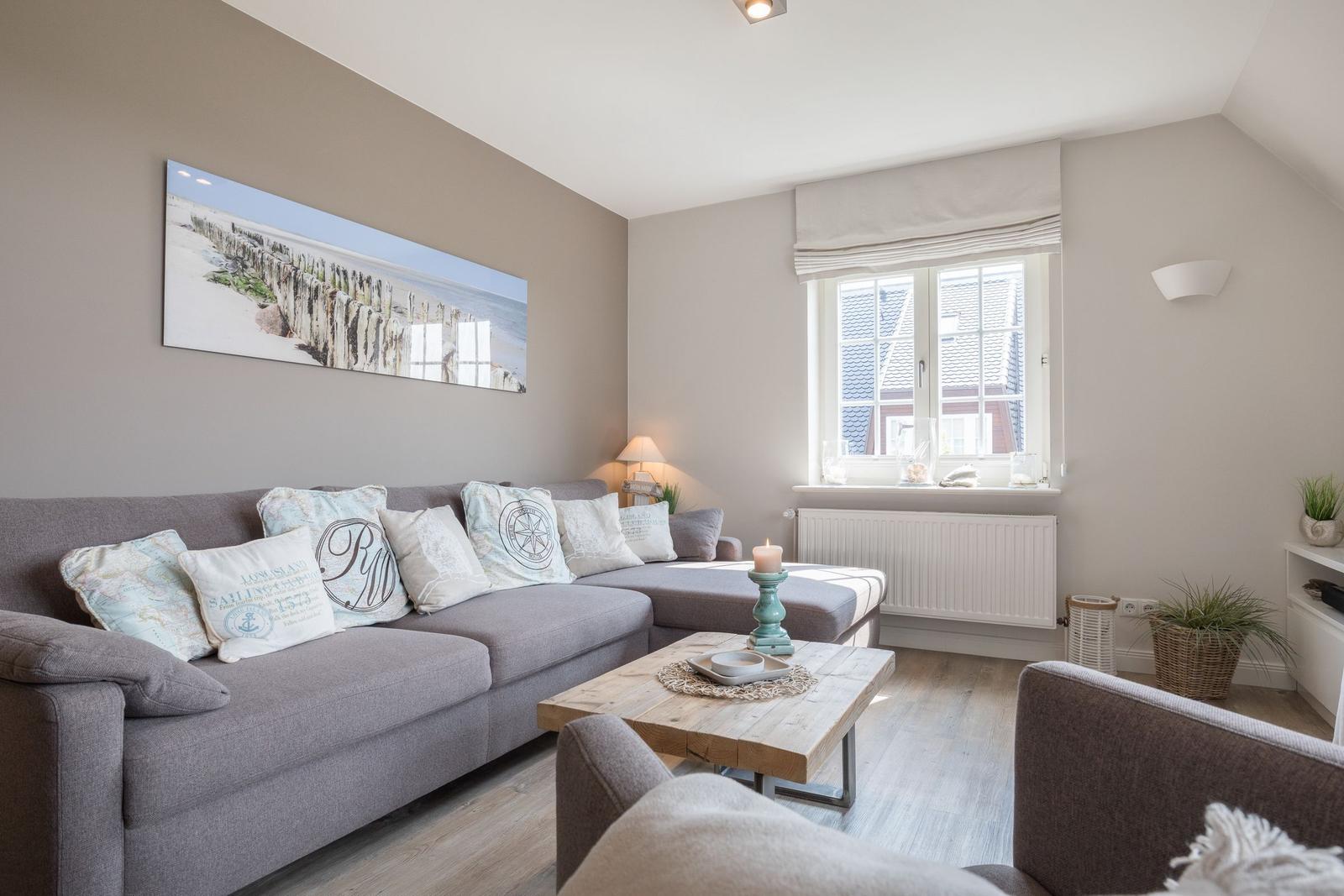 Living room with gray sofa, wooden table, and window with view outside.