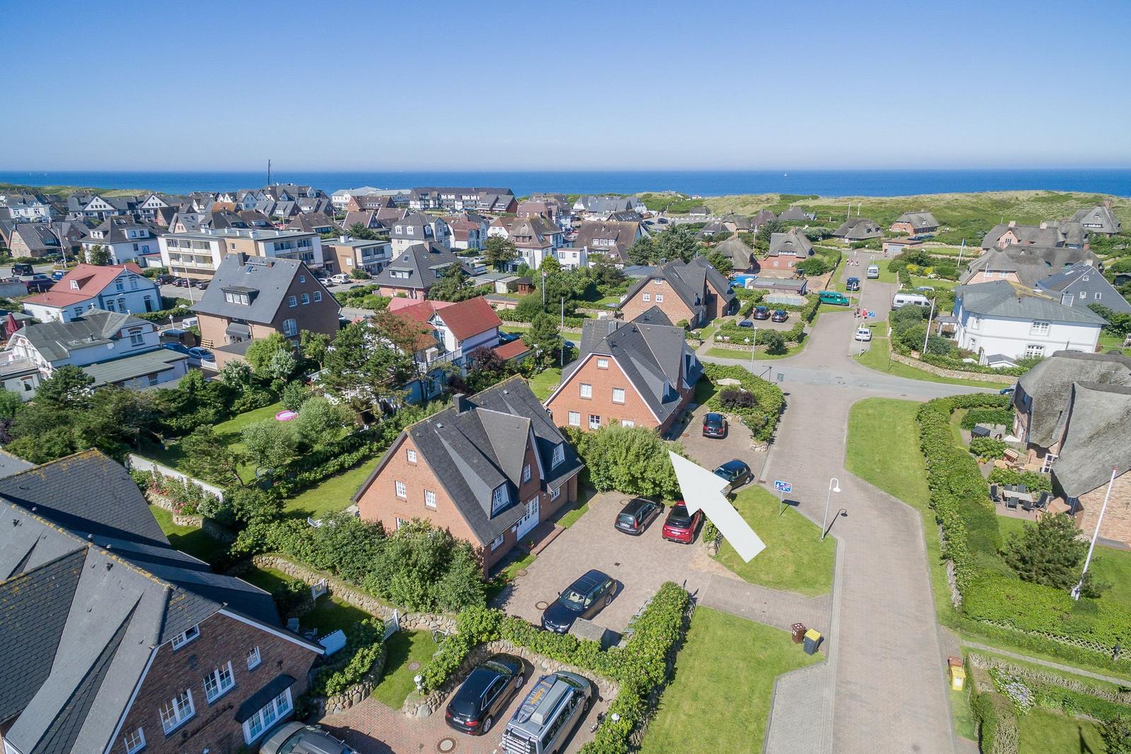 Haus mit Garten und Parkplatz in Küstenort mit Blick auf Meer.