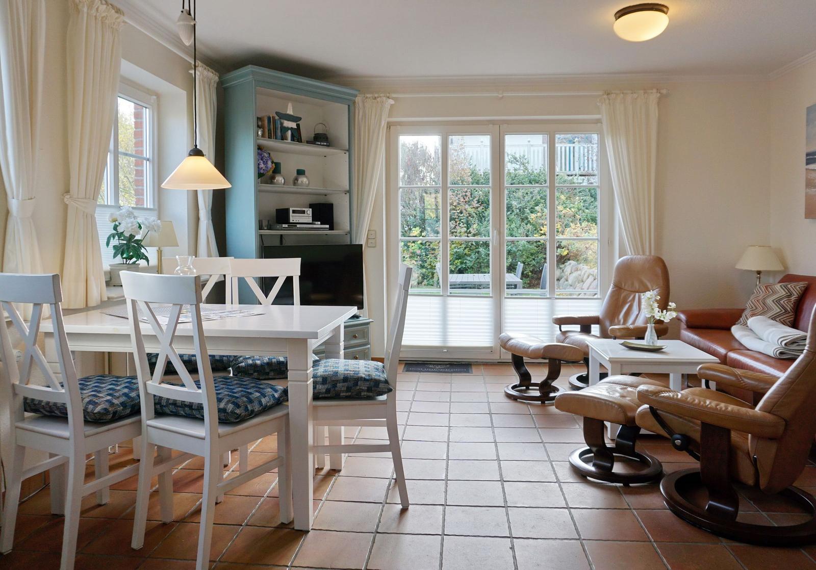 Wohn- und Essbereich mit Sitzgruppe, Esstisch und Glasfront zur Terrasse.