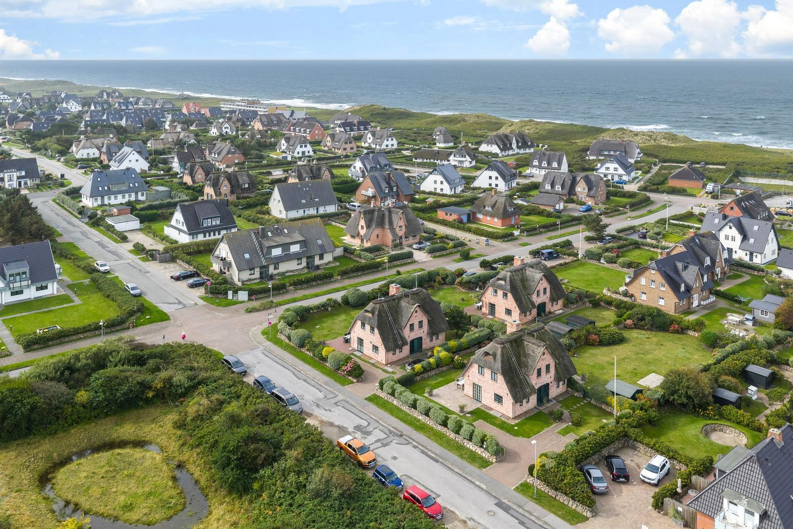 Dorf mit Häusern und Strand im Hintergrund