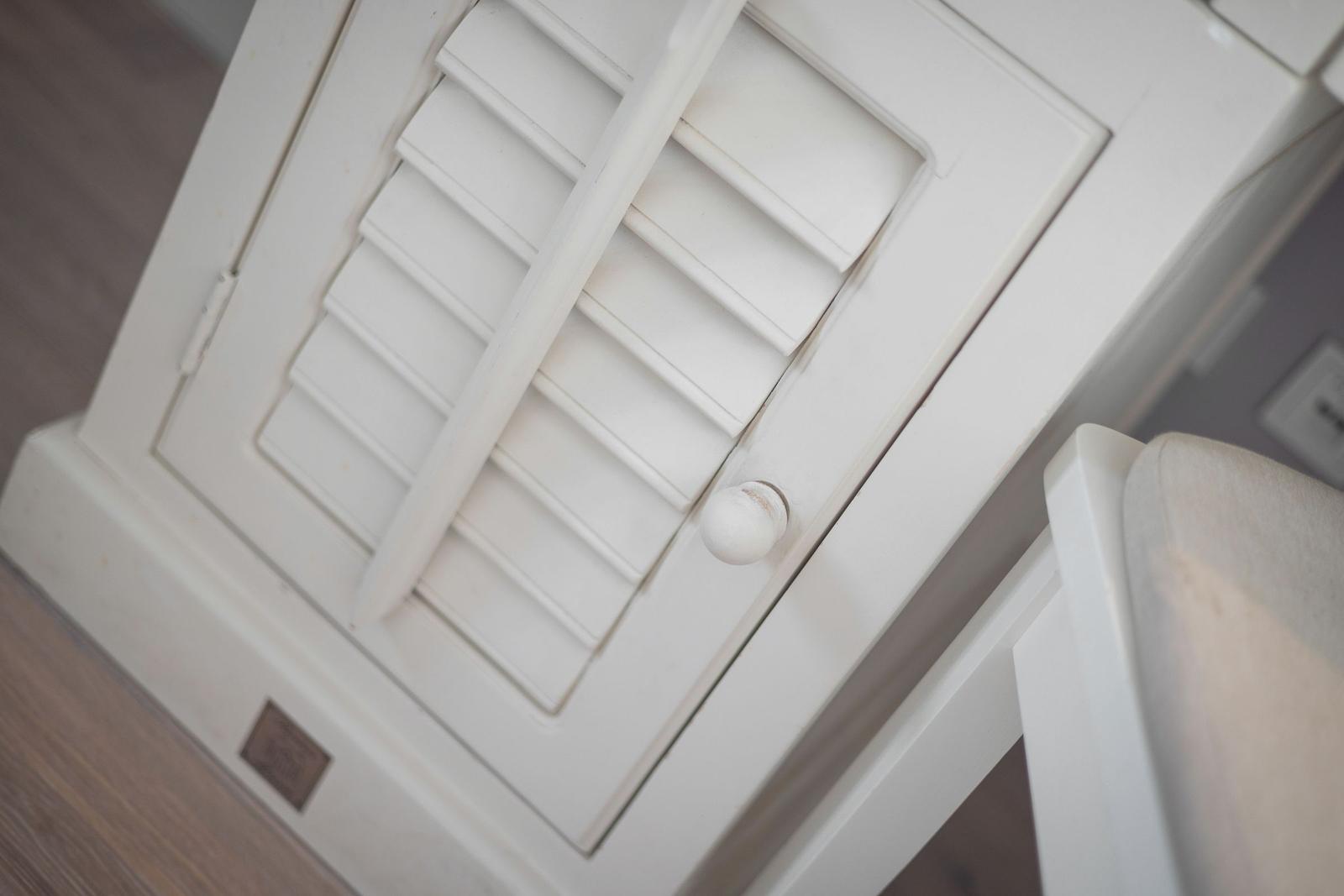 Weißer Schrank mit Latten und Knopf