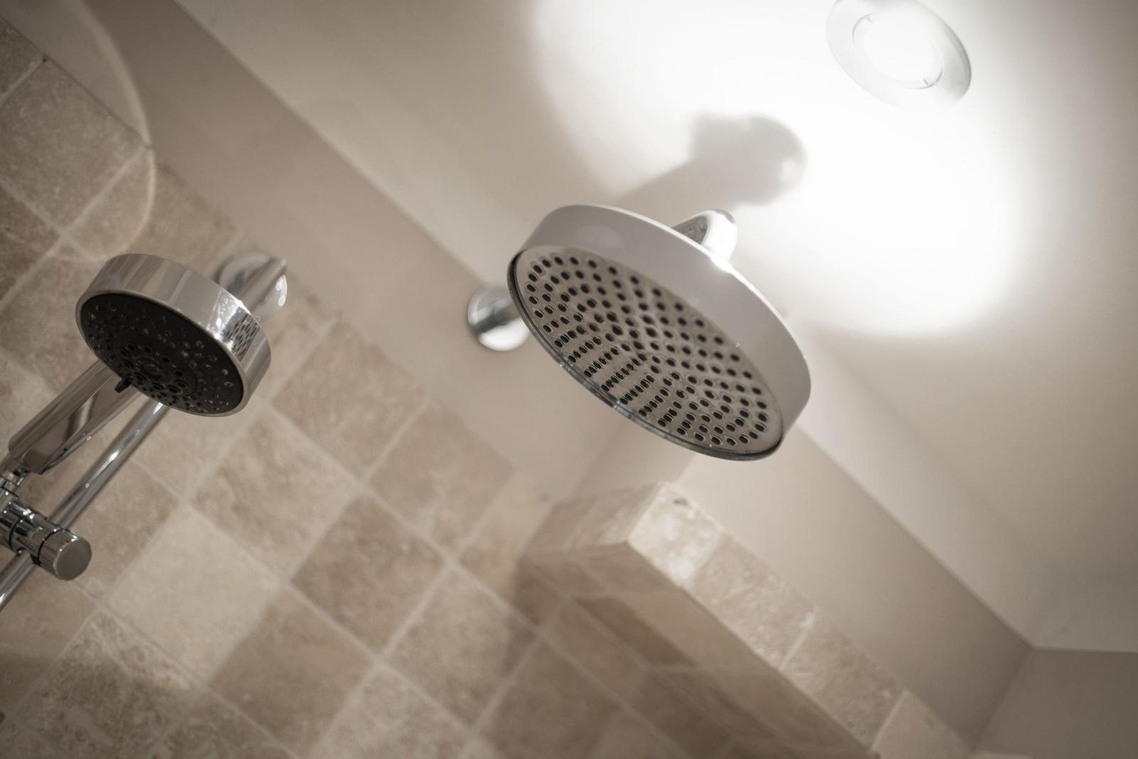 Dusche mit zwei Duschköpfen und hellen Fliesen