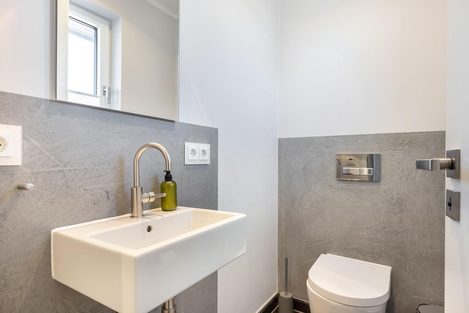 Bathroom with sink, mirror, and toilet