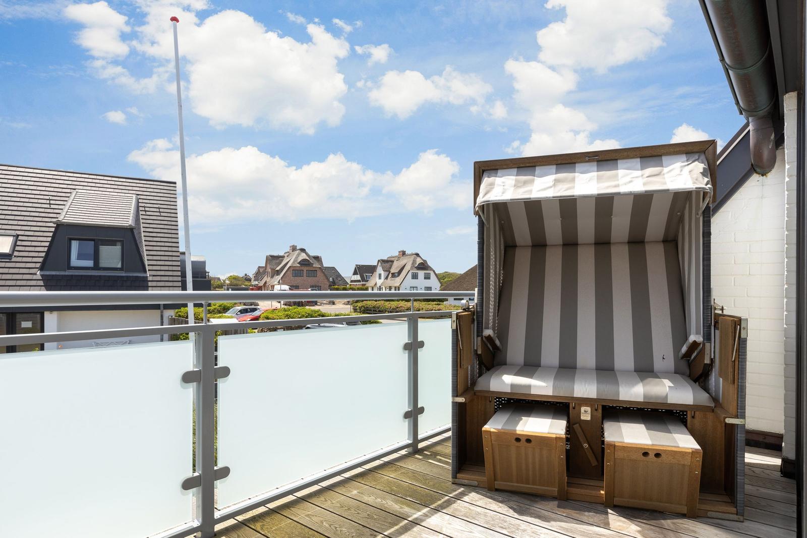Terrace with beach chair and view of residential houses.