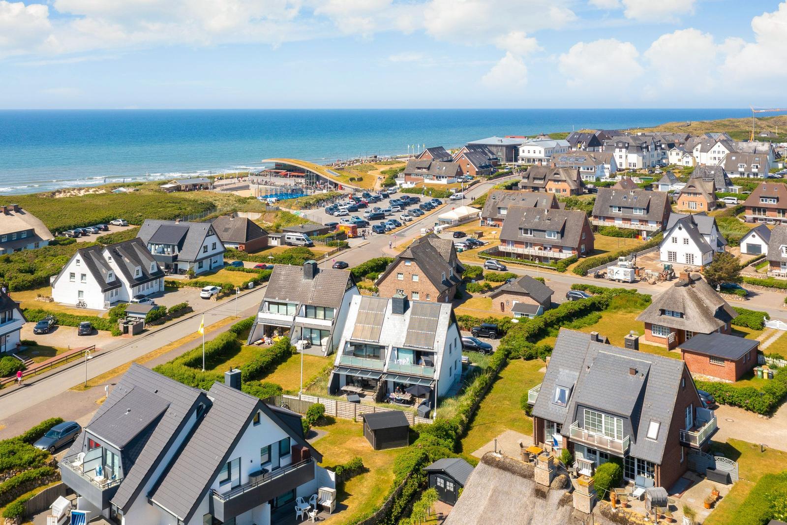 Sea view of holiday homes with beach and parking lot