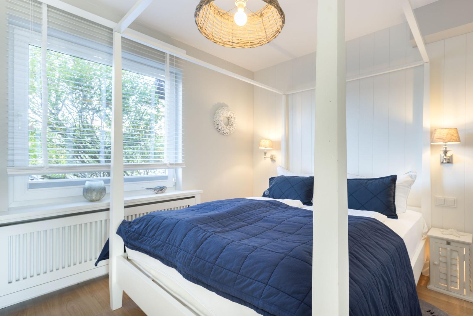 Bedroom with bed, window, and ceiling light.