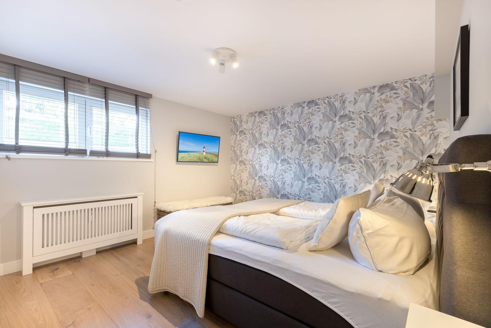 Bedroom with bed, window, and wallpaper