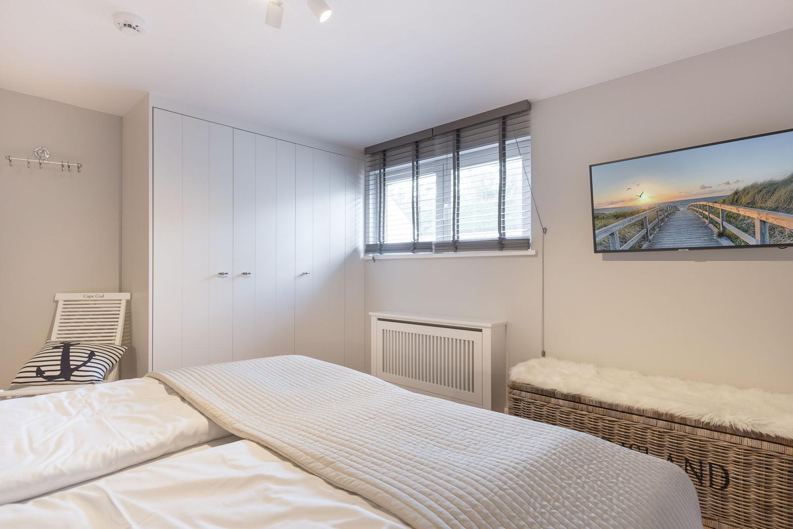 Bedroom with bed, wardrobe, and wall picture