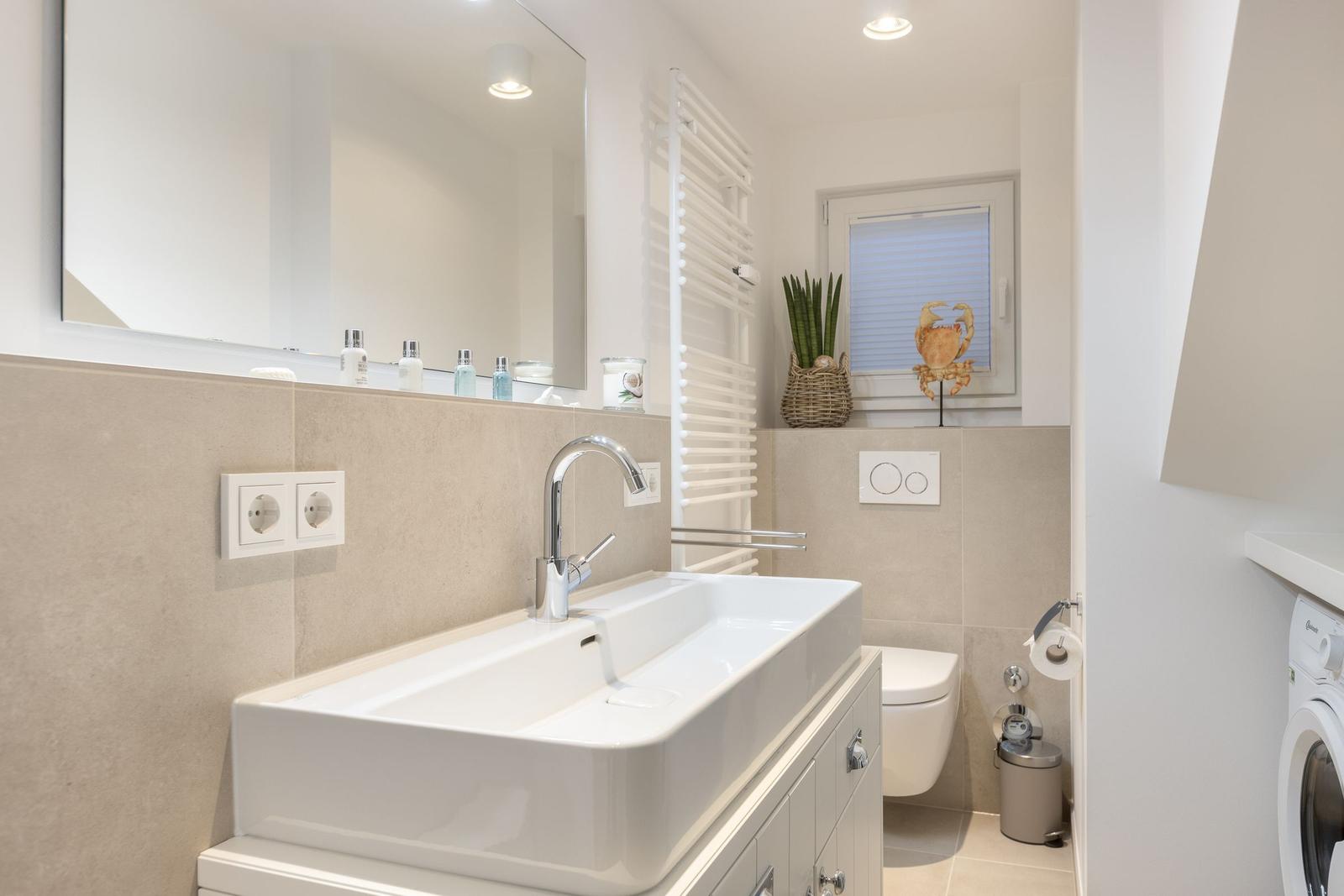 Bathroom with sink, mirror, toilet, and heated towel rail