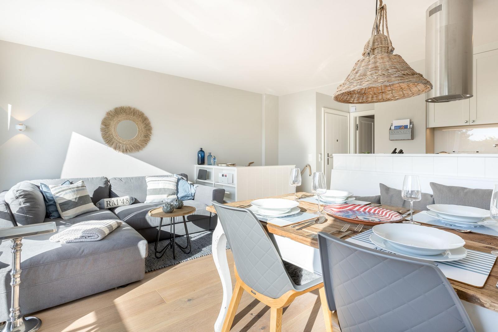 Living and dining area with sofa, table, and pendant lamp.