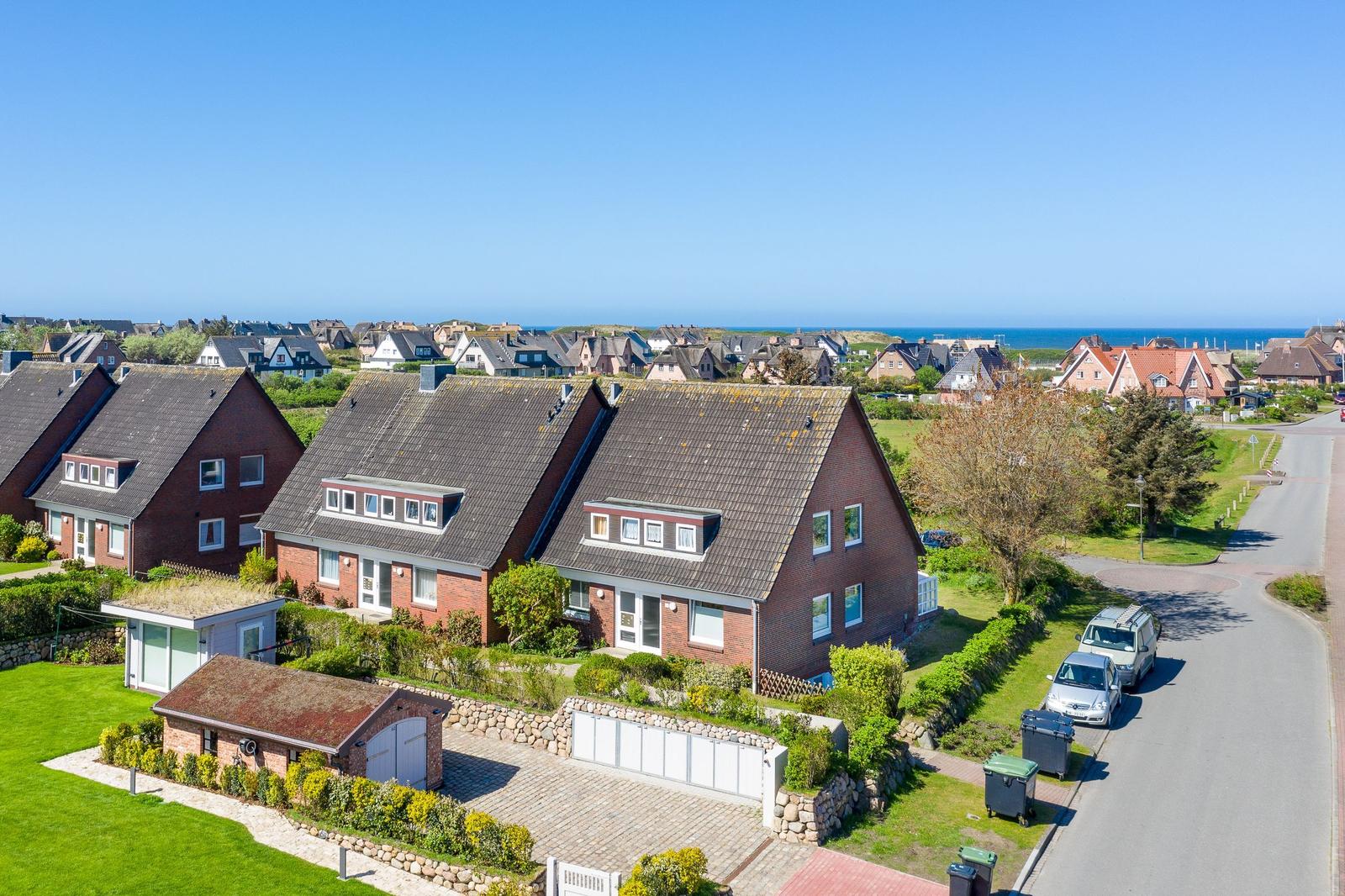 Red brick house with dormers and garden. View of beach and sea.