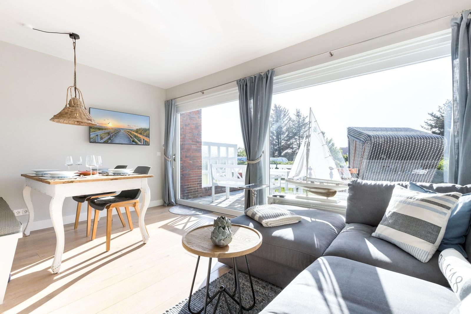 Living and dining area with view of the garden and sailboat.