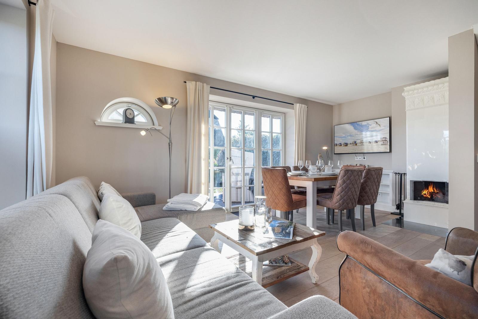 Wohn- und Essbereich mit Kamin, Sofa und Esstisch mit Stühlen.