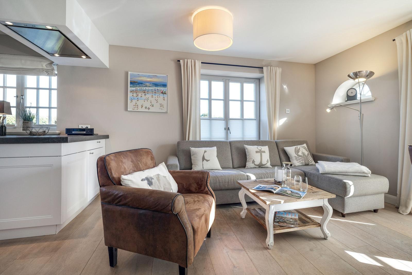 Wohnbereich mit Sofa, Sessel und Küchenzeile