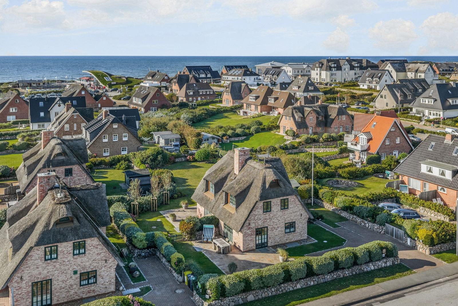Dorf mit strohgedeckten Häusern und Blick auf das Meer.
