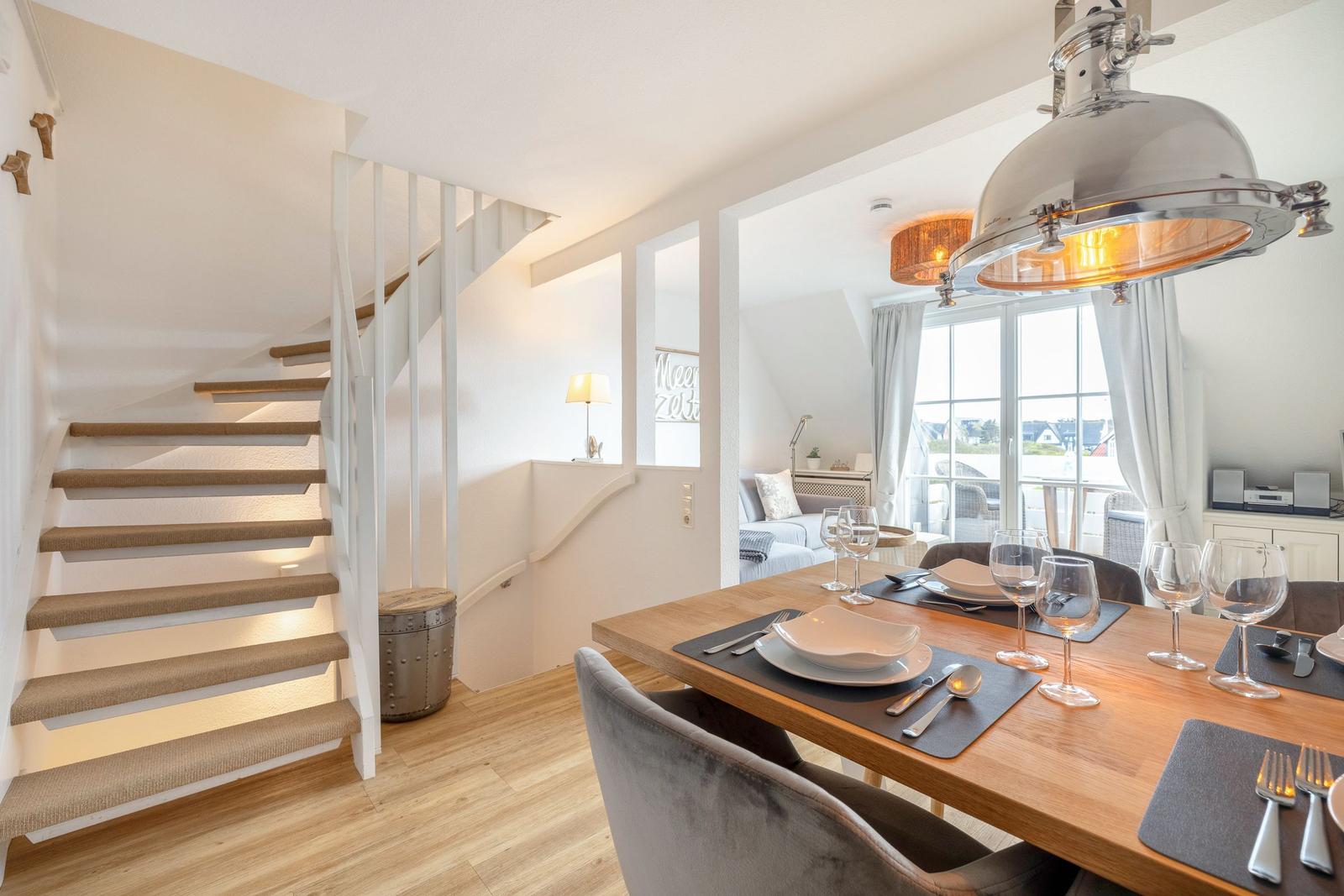 Dining area with table, chairs, and stone staircase to upper level.