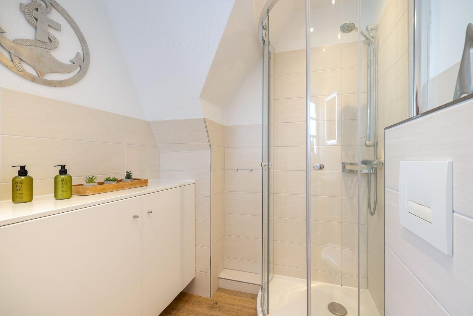 Bathroom with shower, sink, and wall decoration.