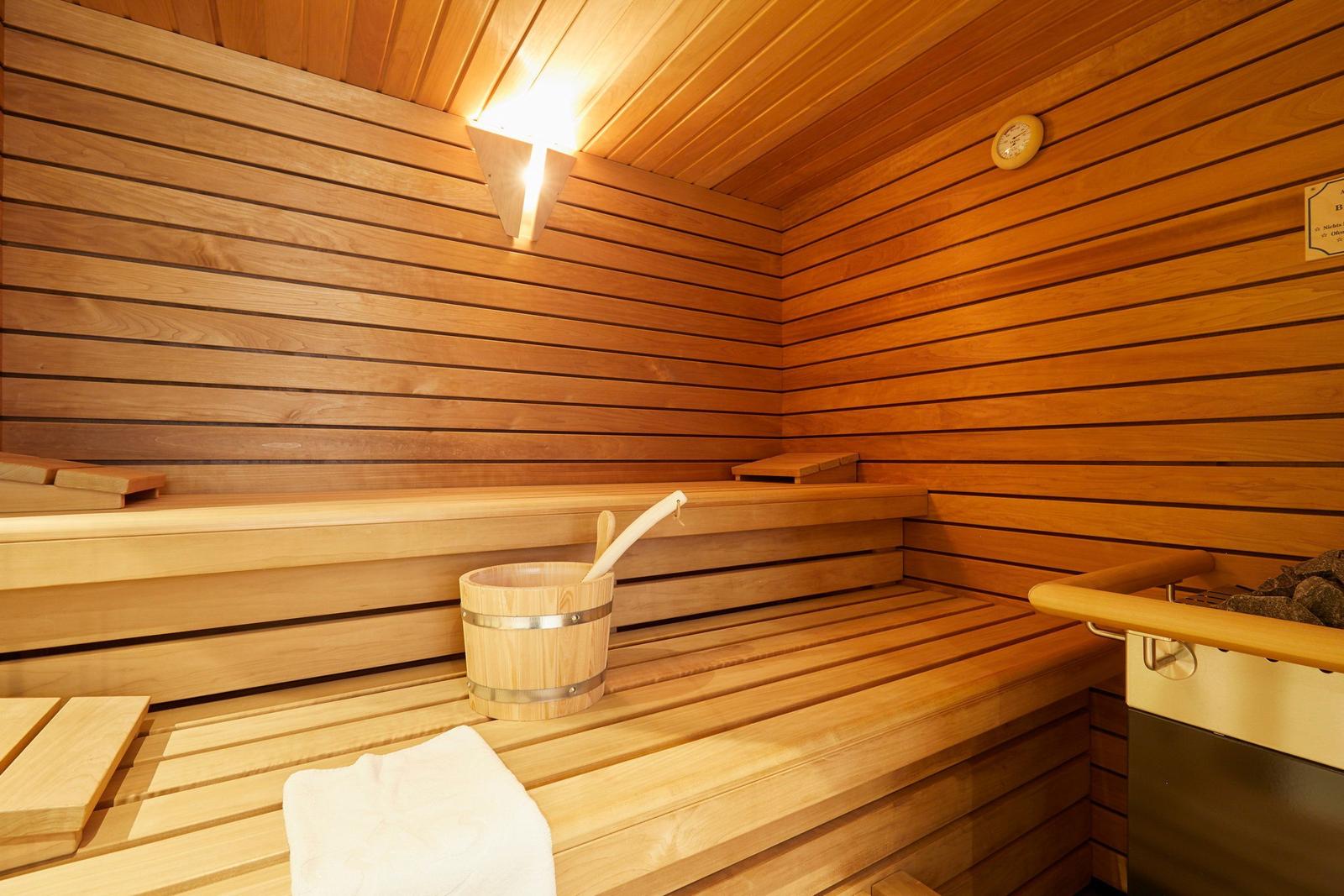Sauna mit Holzbank, Eimer und Handtuch