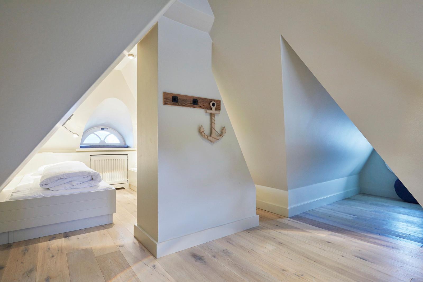 Schlafzimmer mit Dachschrägen, Bett und Fenster