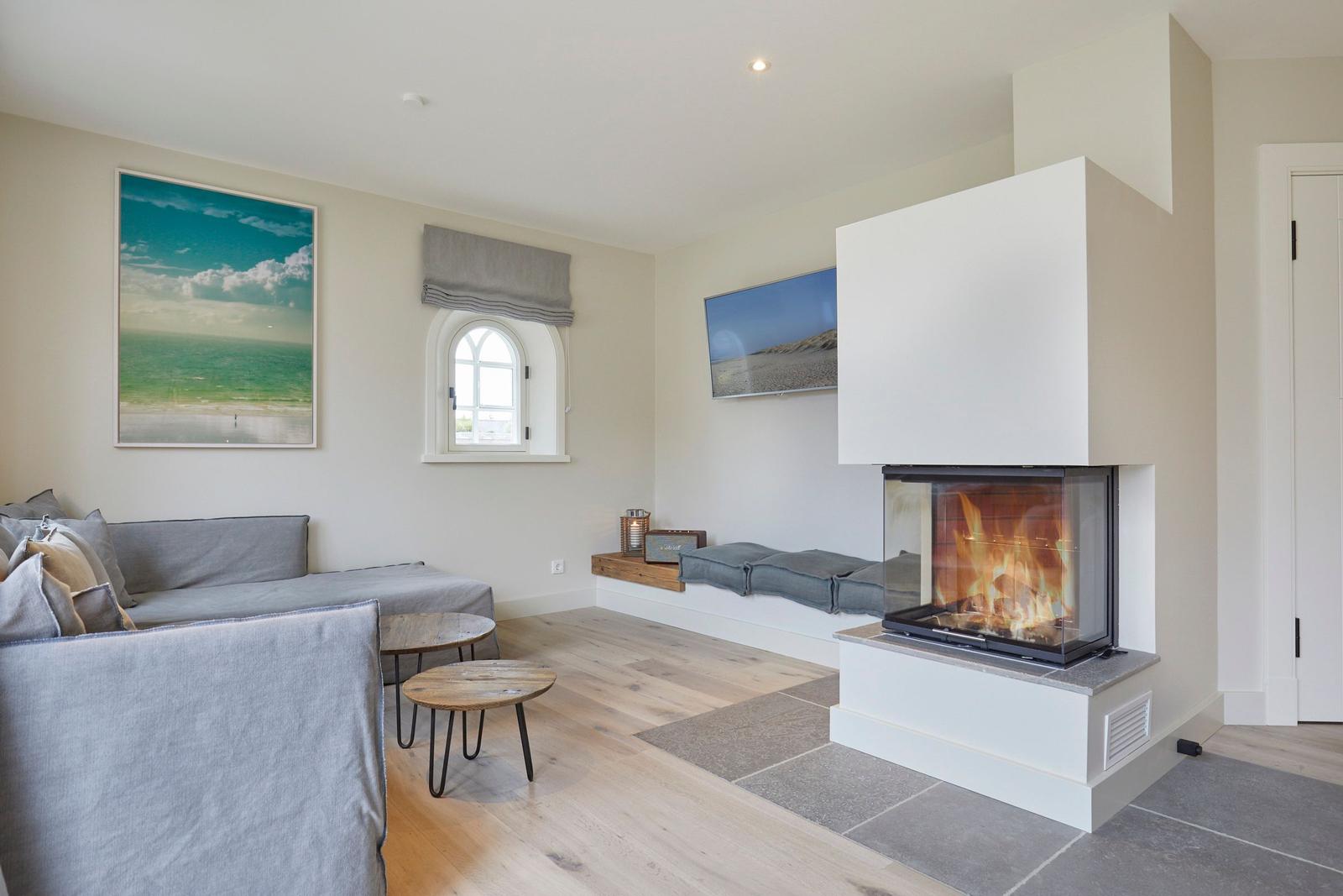 Wohnzimmer mit Kamin, Sofa und Fenster