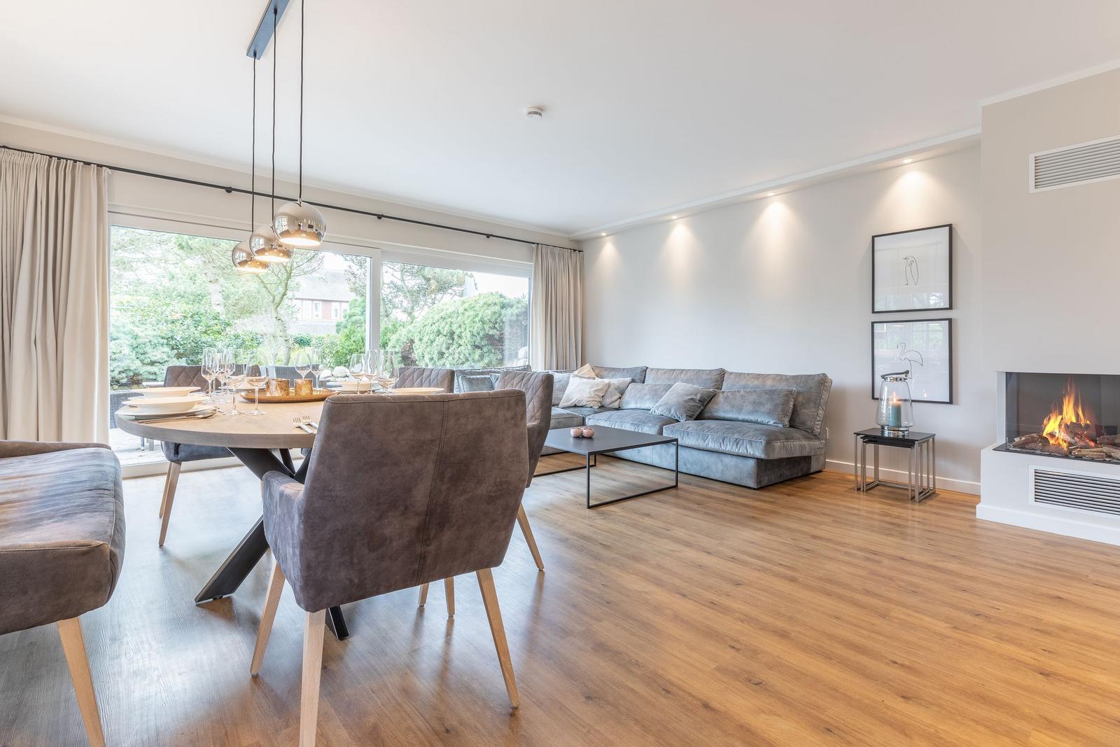 Großer Wohn- und Essbereich mit Sofa, Esstisch und Kamin.