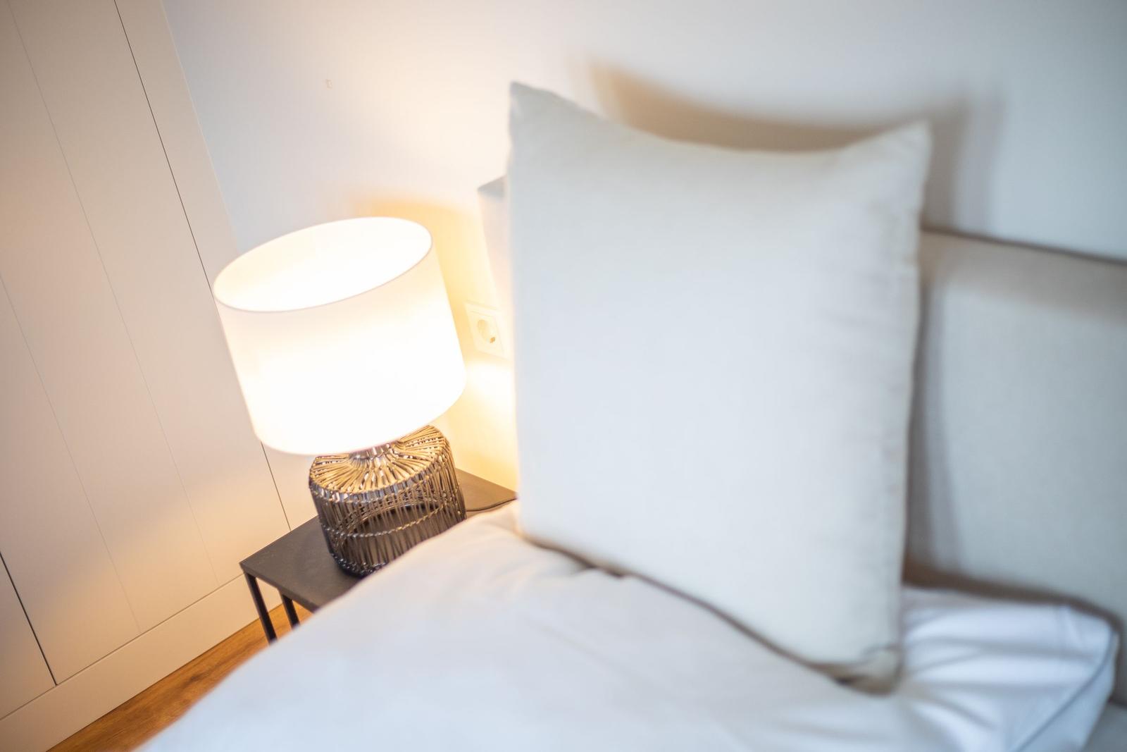Bettkopfteil mit Kissen und Nachttisch mit Lampe