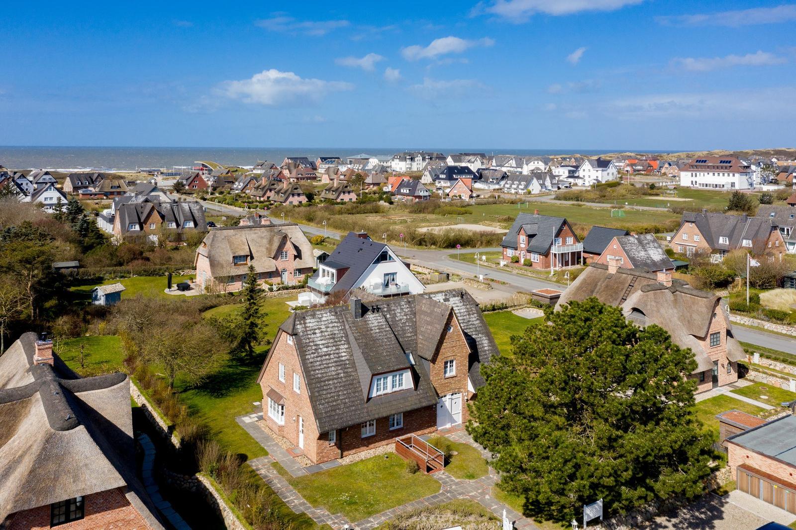 Village with thatched houses and view of the sea