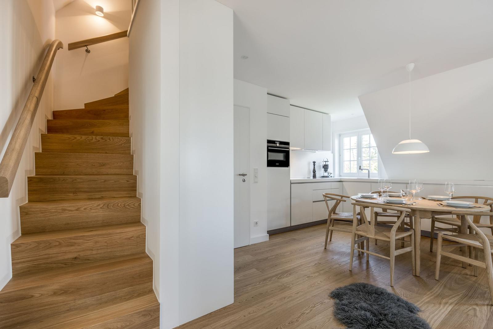 Entrance with stairs, kitchen, and dining table with chairs.