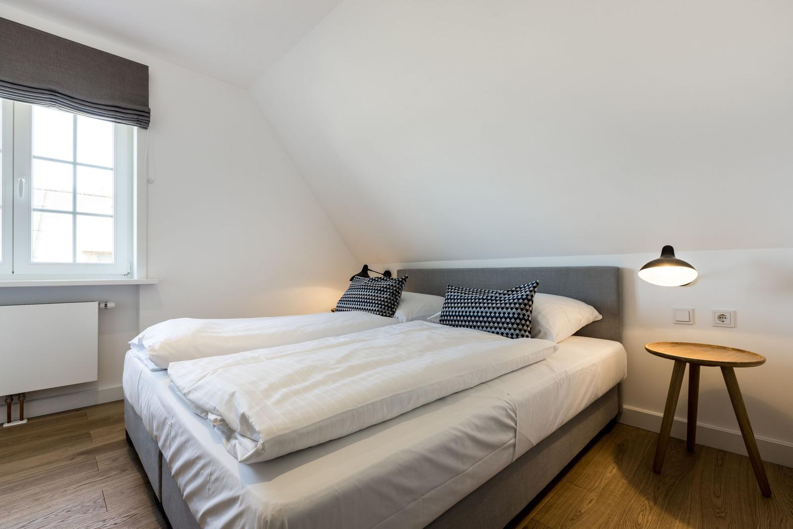 Bedroom with double bed, window, and nightstand.