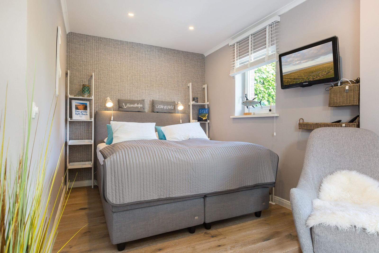 Bedroom with bed, TV, and window.