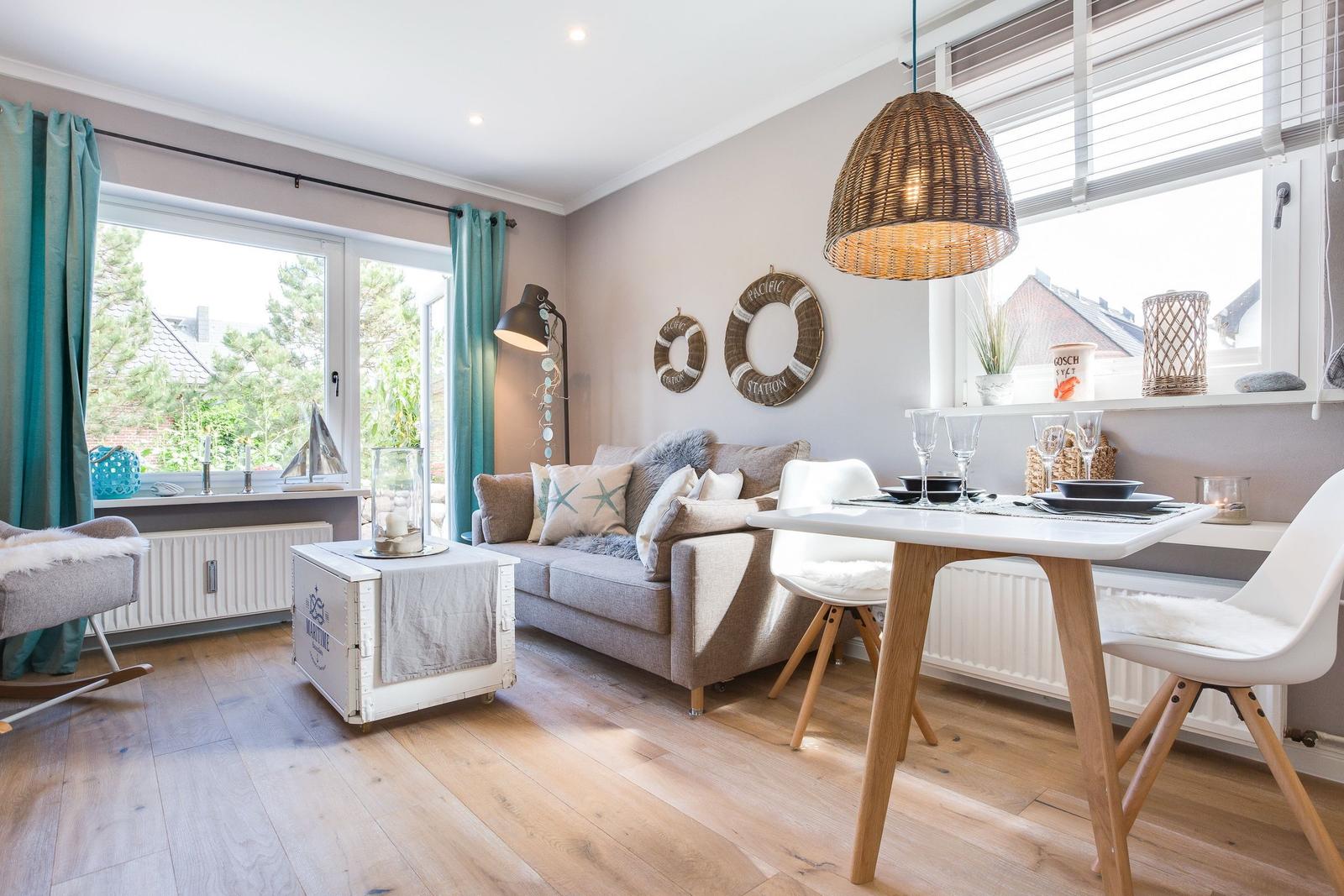 Living and dining area with sofa, table, and windows.