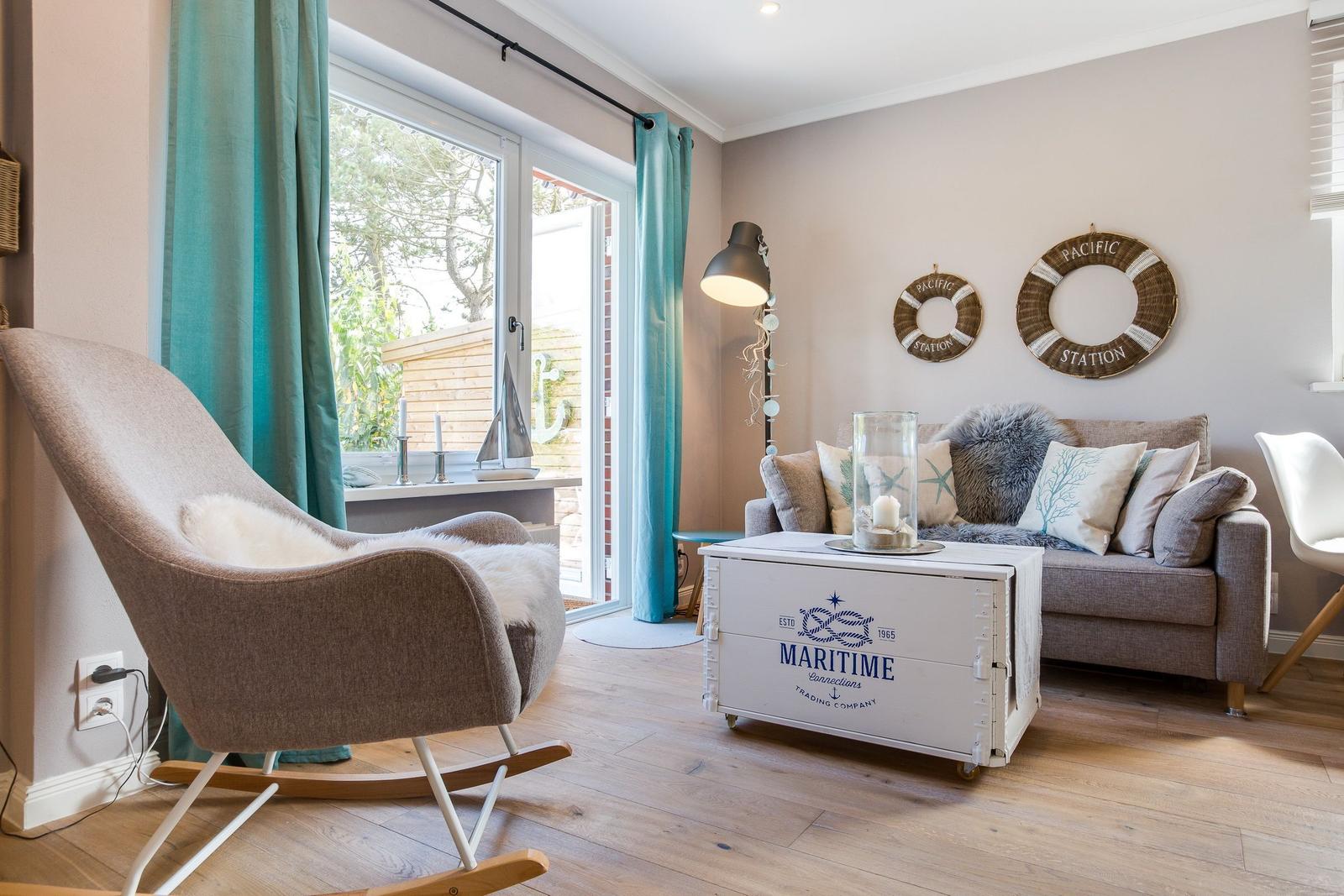 Living room with armchair, sofa, and maritime decorations.