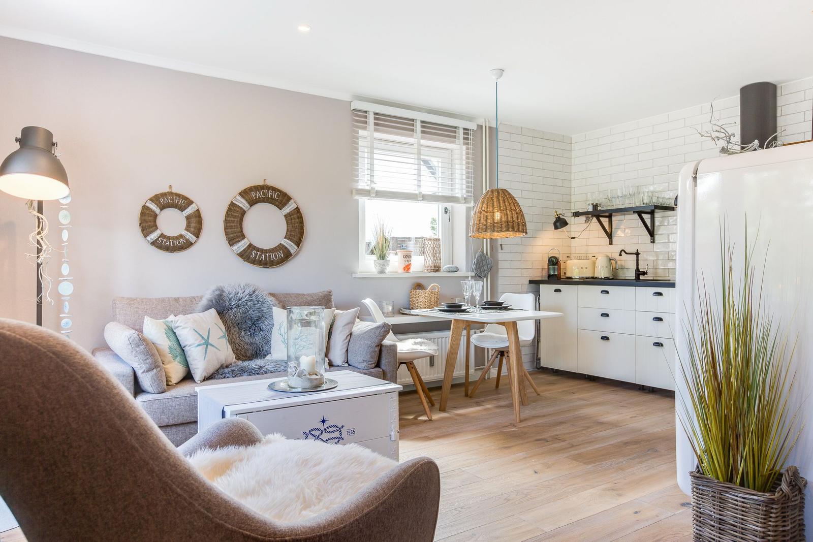 Living and kitchen area with sofa, dining table, and kitchen unit.