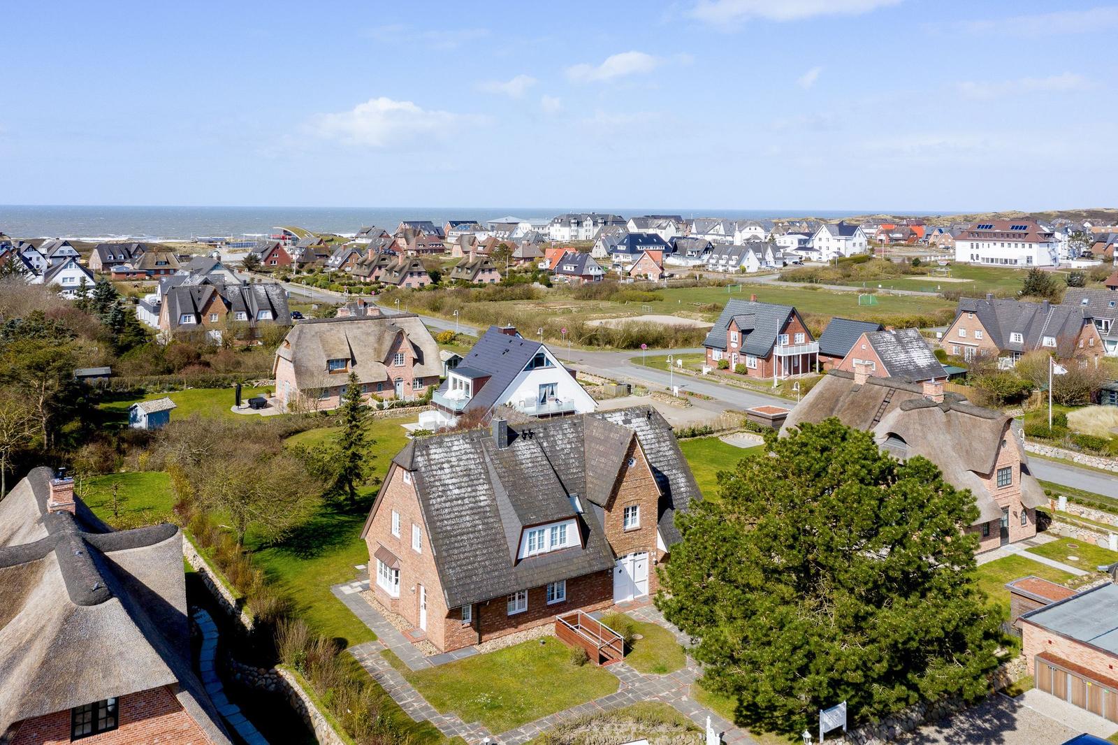 Village with thatched houses and view of the sea.