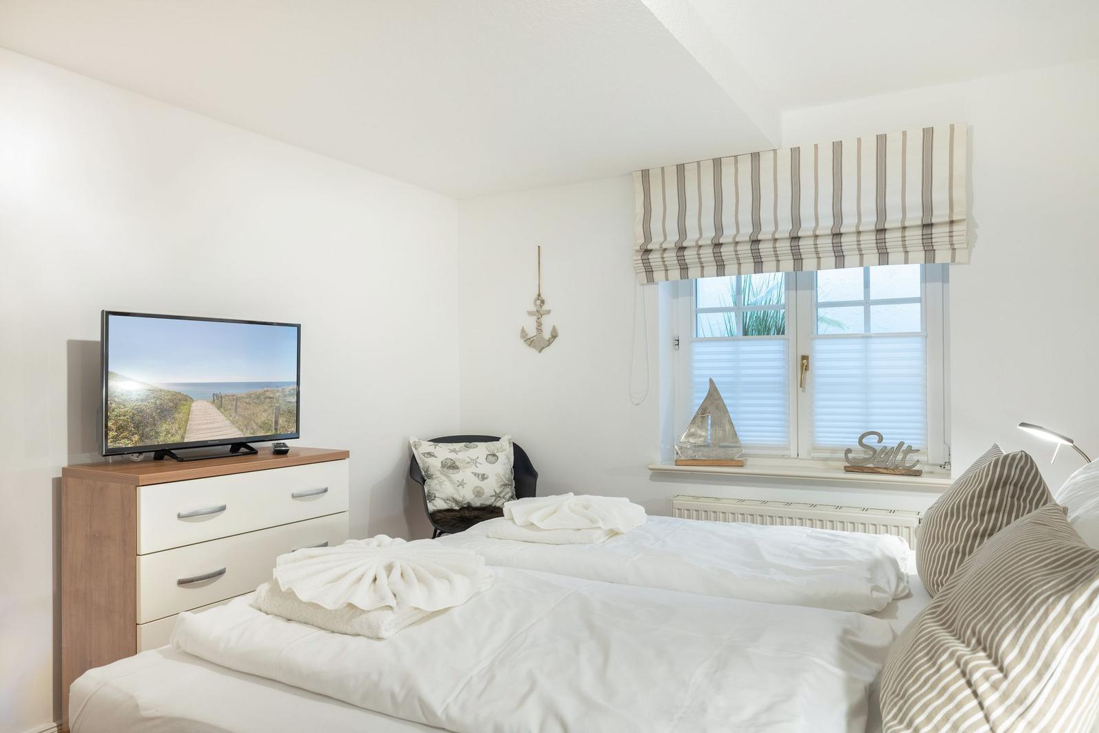 Bedroom with double bed, TV, and window with view.