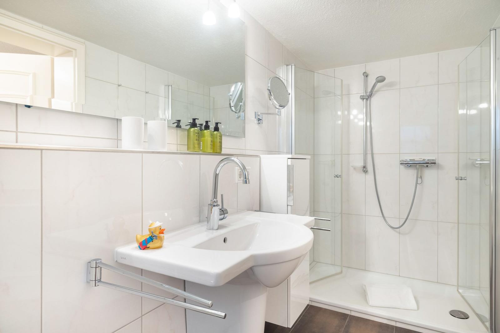 Bathroom with shower, sink, and mirror