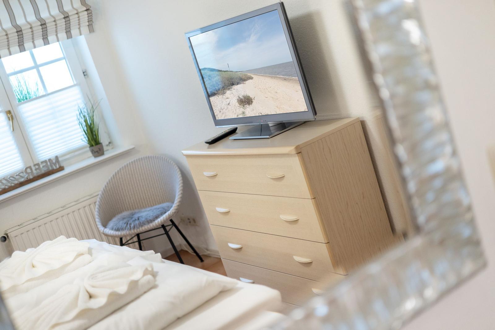 Bedroom with bed, desk, and television.